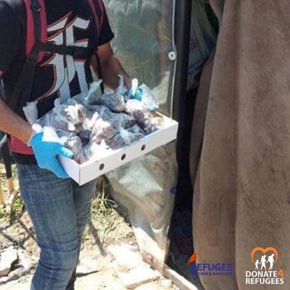 Wearing gloves, a person holds a box of individually wrapped food portions during Ramadan; logos for Refugee Yan & Bananas and Donate4Refugees are visible, highlighting support in Chios, Greece amid the COVID lockdown. | Support refugees across Europe in Greece, France, the UK and the Balkans