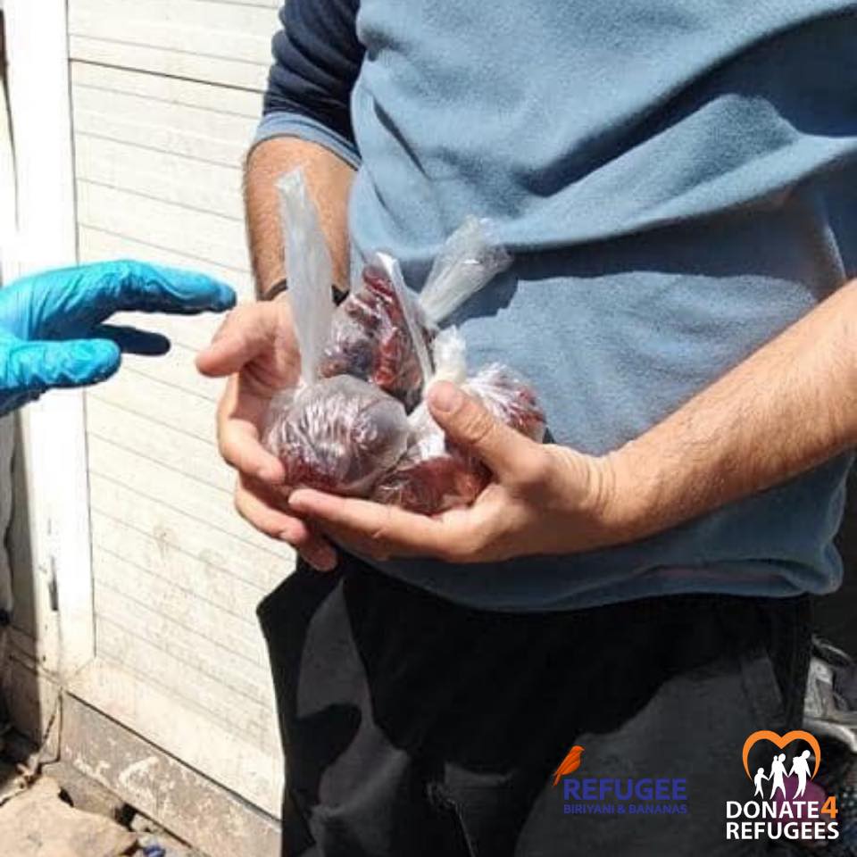 A person holds several small plastic bags containing food while another wearing a blue glove reaches toward them; refugee aid logos and a mention of Ramadan are visible, capturing a moment of support in Chios, Greece during the COVID lockdown. | Support refugees across Europe in Greece, France, the UK and the Balkans