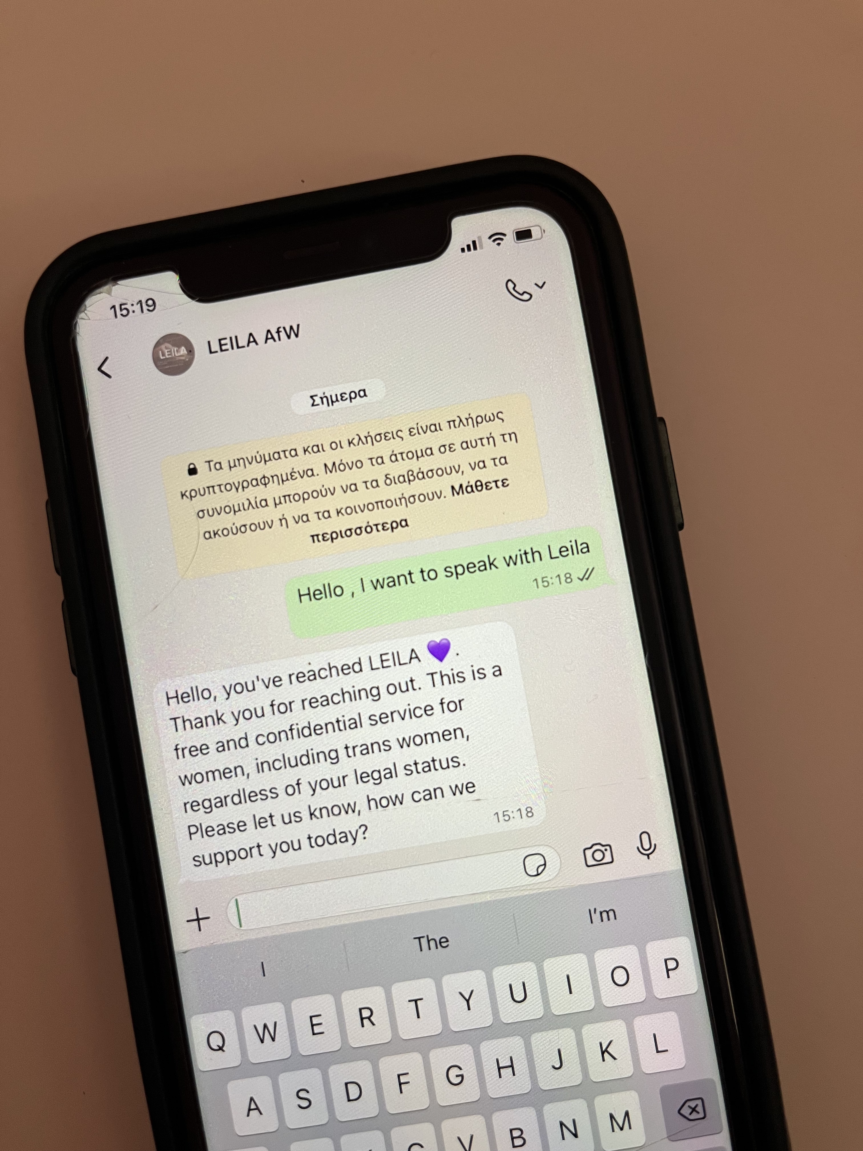 A smartphone displays a WhatsApp chat with LEILA AfW, a support network in Greece offering confidential support for trans women, legal status inquiries, and refugee domestic violence assistance. | Support refugees across Europe in Greece, France, the UK and the Balkans